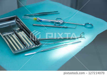 A Comprehensive Overview of Dental Instruments Displayed on a Clean Blue Surface in a Clinical Setting Ready for Use in Various Dental Procedures A Comprehensive Overview of Dental Instruments Displayed on a Clean Blue Surface in a Clinical Setting Ready for Use in Various Dental Procedures 127214070