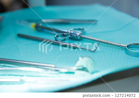 A Close-Up of Various Surgical Instruments Arranged on a Serene Aquamarine Surface, Ready for Use in Medical Procedures and Surgeries in a Healthcare Setting A Close-Up of Various Surgical Instruments Arranged on a Serene Aquamarine Surface, Ready for Use in Medical Procedures and Surgeries in a Healthcare Setting 127214072
