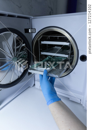 A Technician in Blue Gloves Is Operating a Laboratory Freeze Dryer, Extracting Items from the Chamber to Preserve Various Samples for Research and Experimental Purposes 127214102