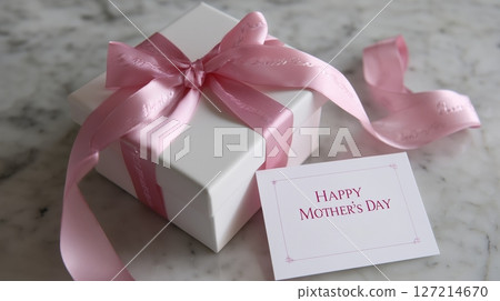 Special gift wrapped in white with a pink ribbon and a greeting card for Mother's Day celebration Special gift wrapped in white with a pink ribbon and a greeting card for Mother's Day celebration 127214670