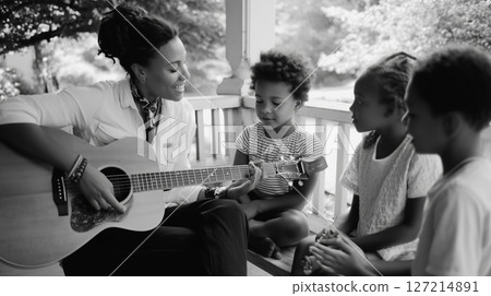 Young adults enjoy a music lesson on a cozy porch while children listen and engage with the performance Young adults enjoy a music lesson on a cozy porch while children listen and engage with the performance 127214891