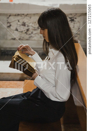 Woman Flipping The Pages Of The Old Sacred Book While Sitting In Church Woman Flipping The Pages Of The Old Sacred Book While Sitting In Church 127215065
