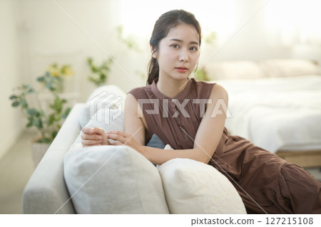 一位 20 多歲的女性在沙發上休息 — — 美女圖片 127215108