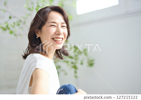 A woman in her 50s doing yoga in yoga wear 127215122
