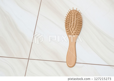 Wooden Hair Brush on Clean Ceramic Floor Minimalist Natural Styling Concept Wooden Hair Brush on Clean Ceramic Floor Minimalist Natural Styling Concept 127215273
