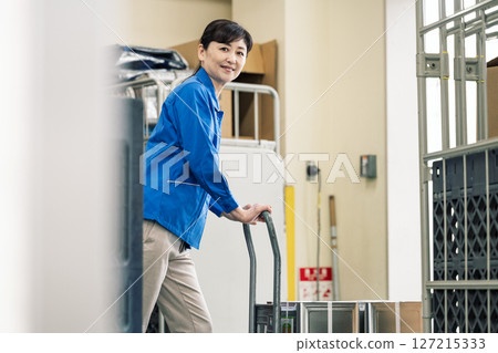 一名 50 多歲的女性在物流倉庫工作 127215333