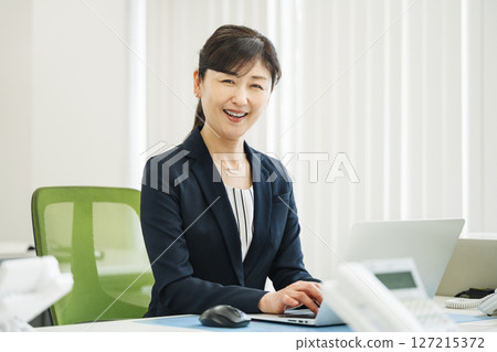 A career woman in her 50s working energetically in a business office 127215372