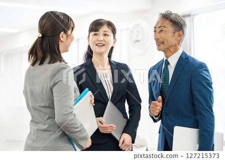 Middle-aged and senior business people working in an office Middle-aged and senior business people working in an office 127215373