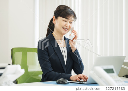 A career woman in her 50s making a phone call in the office 127215383