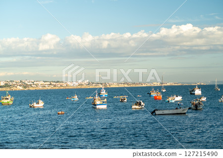 Fishing Boats Occupy a Tranquil Seascape Under a 127215490