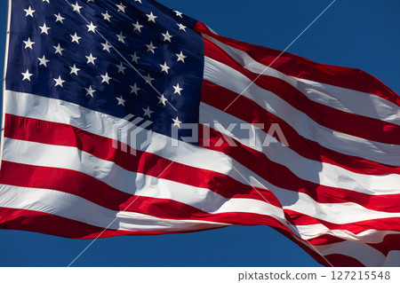 American Flag Waving In The Wind Against Deep Blue Sky. 127215548