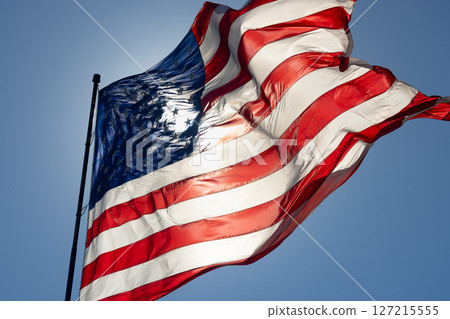 Dramatic Backlit American Flag Waving in the Wind. Dramatic Backlit American Flag Waving in the Wind. 127215555