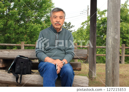 An old man taking a break during a walk An old man taking a break during a walk 127215853