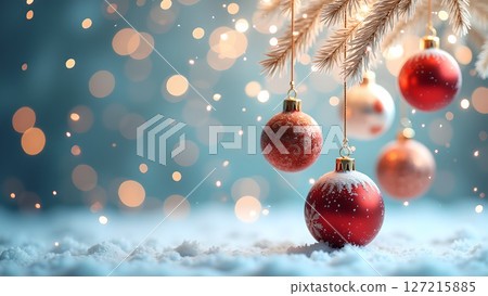 Festive christmas ornaments hanging gracefully from a snowy pine branch 127215885