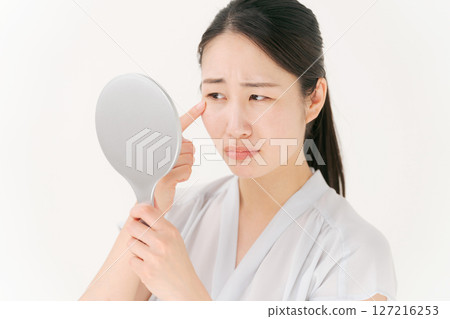 一個女人對著鏡子，一臉苦惱 127216253