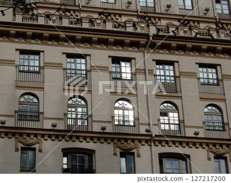 This architectural mockup highlights an impressive facade with ornate balconies and decorative window detailing, reflecting sunlight. The intricate design adds character to the urban landscape. This architectural mockup highlights an impressive facade with ornate balconies and decorative window detailing, reflecting sunlight. The intricate design adds character to the urban landscape. 127217200