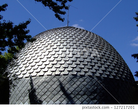 A dome-shaped architectural mockup is showcased with a textured exterior. The bright blue sky serves as a backdrop, highlighting the unique design and structure. A dome-shaped architectural mockup is showcased with a textured exterior. The bright blue sky serves as a backdrop, highlighting the unique design and structure. 127217201