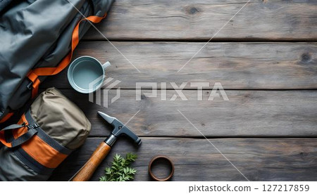 A wooden floor highlights a travel backpack and hiking gear, prepared for a camping trip or a hiking adventure in the forest 127217859