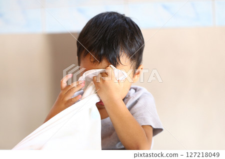 Emotional Moment of a Young Child Hiding Face Behind a White Cloth While Experiencing Sadness or Frustration in Soft Indoor Light Setting Emotional Moment of a Young Child Hiding Face Behind a White Cloth While Experiencing Sadness or Frustration in Soft Indoor Light Setting 127218049