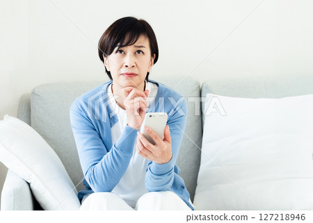 一位操作智能手機的中年婦女 127218946