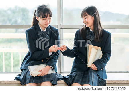 Two friendly junior high school girls in uniforms making a pinky promise (promise, exam, career path) Two friendly junior high school girls in uniforms making a pinky promise (promise, exam, career path) 127218952