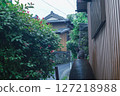 A black cat sitting on a jar in an alley after the rain and a Japanese-style streetscape 127218988