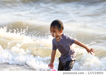Young boy playing joyfully at the beach, splashing water with a playful expression while enjoying a sunny day by the shore, embodying the spirit of childhood spontaneity. Young boy playing joyfully at the beach, splashing water with a playful expression while enjoying a sunny day by the shore, embodying the spirit of childhood spontaneity. 127219093