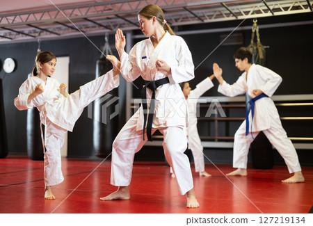 Female trainer and girl training karate in pairs Female trainer and girl training karate in pairs 127219134