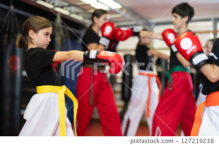 Boy with girl fight with feet and hands, using all strength, courage. Kickboxing and boxing lesson Boy with girl fight with feet and hands, using all strength, courage. Kickboxing and boxing lesson 127219238