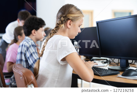 Girl student learning to work on computer in classroom 127219258
