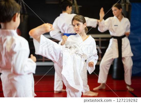 Boy and girl train to perform defensive karate installations and attacking combat techniques 127219292