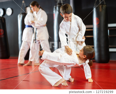 Teenage boy and girl practicing karate Teenage boy and girl practicing karate 127219299