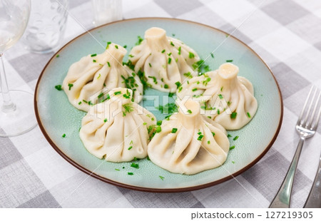 Georgian khinkali dumplings served with herbs Georgian khinkali dumplings served with herbs 127219305