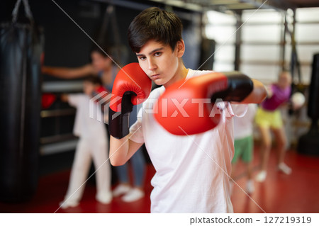 Boy posing during training in boxing gloves 127219319