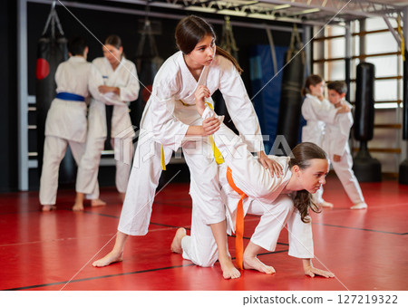 Teenage girls in kimono at judo lesson Teenage girls in kimono at judo lesson 127219322