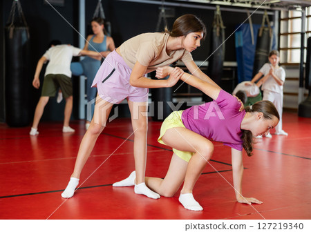 Two teenage girls practice self-defense in pairs Two teenage girls practice self-defense in pairs 127219340