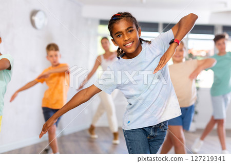 Cheerful african american tween boy training dynamic dance moves Cheerful african american tween boy training dynamic dance moves 127219341