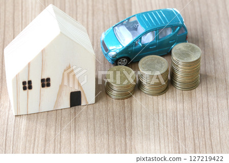 Wooden House and Car with Stacked Coins on Table 127219422