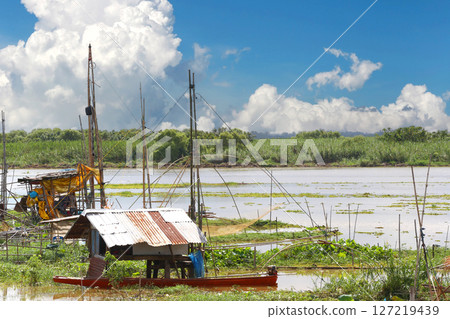 Local fishermen's riverside huts and nets for catching fish. Local fishermen's riverside huts and nets for catching fish. 127219439