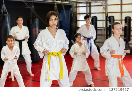 Children students repeat position and perform sequence of punches and painful techniques kata Children students repeat position and perform sequence of punches and painful techniques kata 127219467