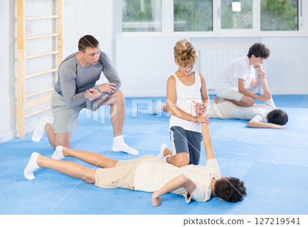 Teenager applying armlock technique to face-down opponent at self-defense classes Teenager applying armlock technique to face-down opponent at self-defense classes 127219541