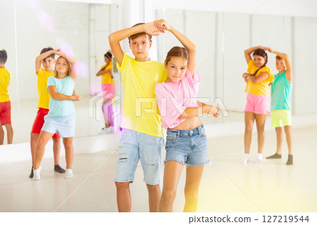 Young boys and girls dancing salsa in dance room Young boys and girls dancing salsa in dance room 127219544
