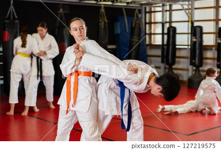 Teenage boy and girl training judo in pairs Teenage boy and girl training judo in pairs 127219575