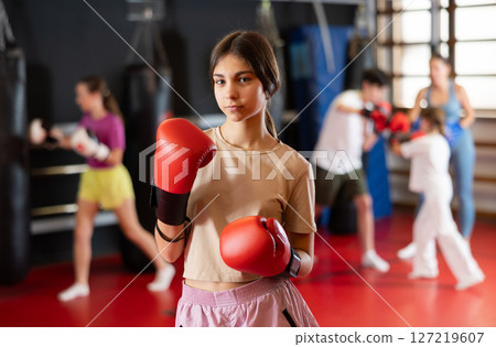 Teenage girl in boxing gloves in training 127219607