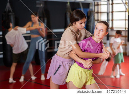 Girls practice self-defense strikes in the gym 127219644