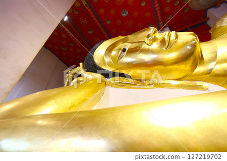 Close-up of the golden Buddha statue in a reclining position. 127219702