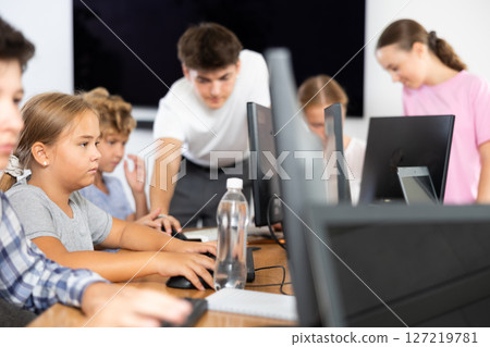Girl student learning to work on computer in classroom 127219781
