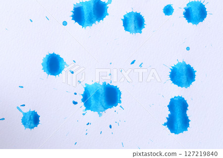 Blue color paint drops on paper, causing dispersion of color. 127219840