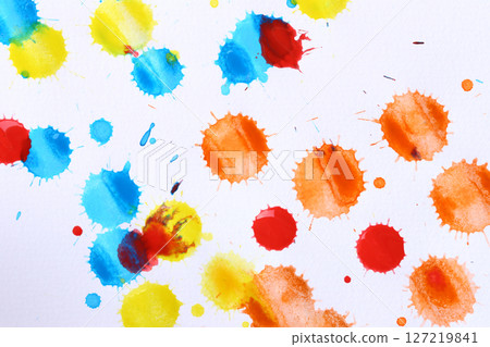 Various color paint drops on paper, causing dispersion of color. 127219841