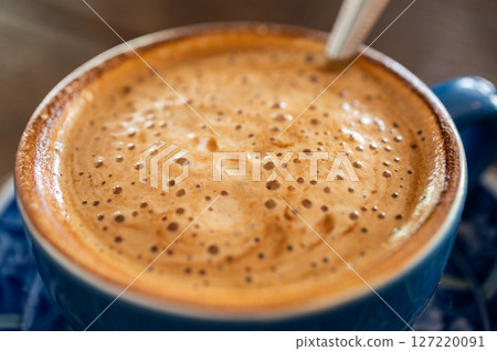 Close up of the surface of hot latte coffee. A latte is a coffee drink made with espresso and steamed milk. 127220091